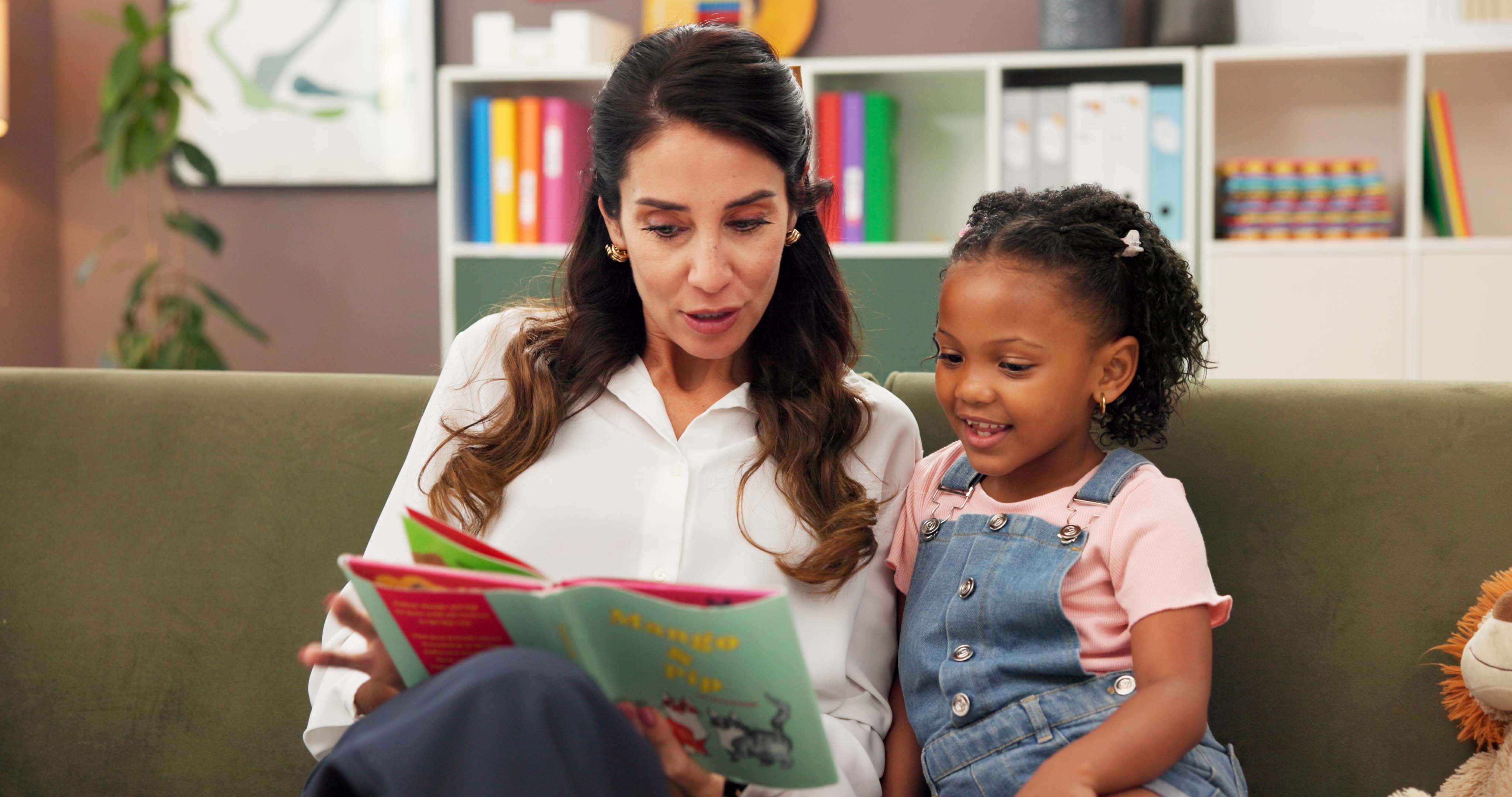 A woman and young girl look at picture books together