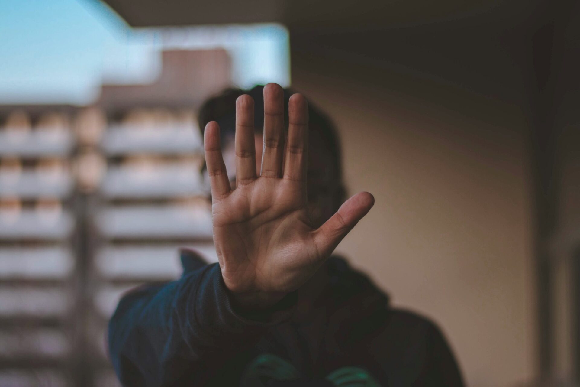 A hand raised in front of a person's face indicating %22stop%22, Credit: Nadine Shaabana for Unsplash.