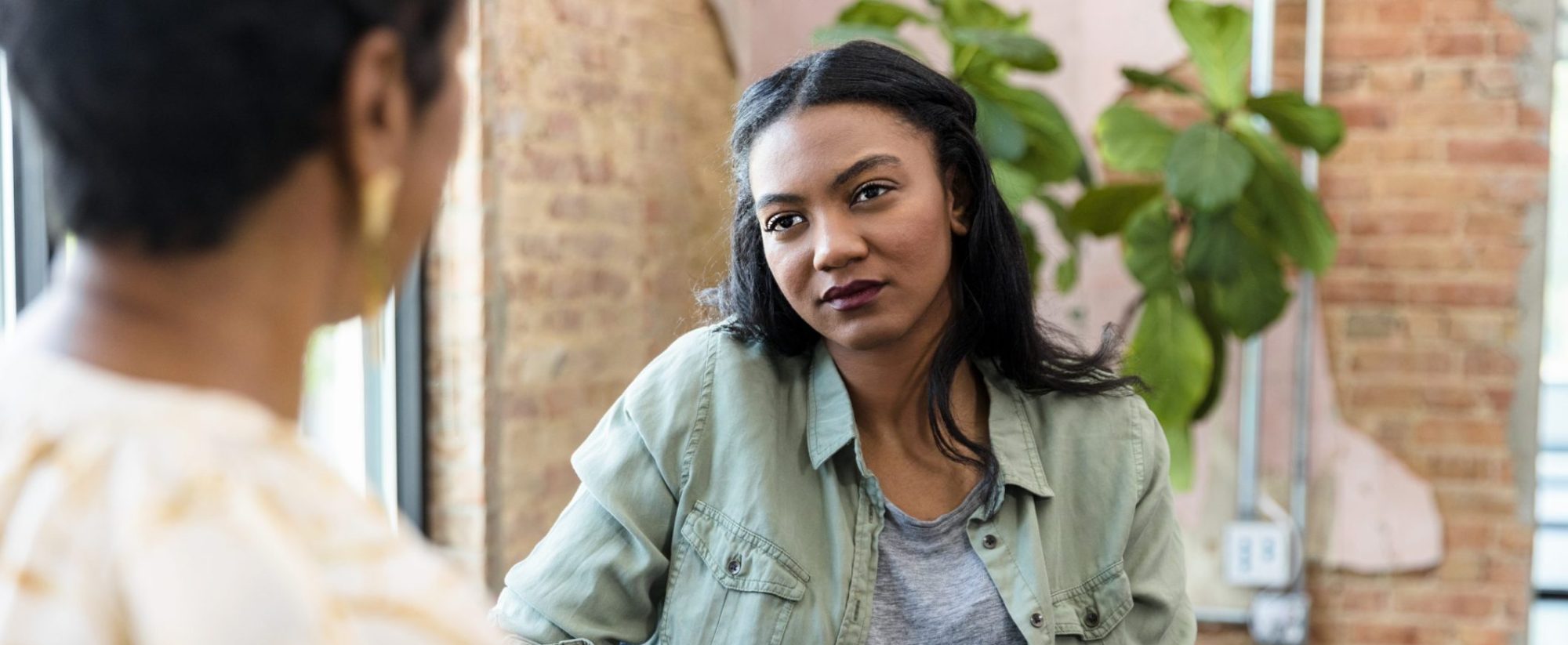 Young woman focuses on female counselor's advice